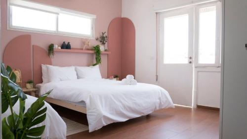 a bedroom with a white bed and two windows at Meir's Boutique Guesthouse in Tel Aviv
