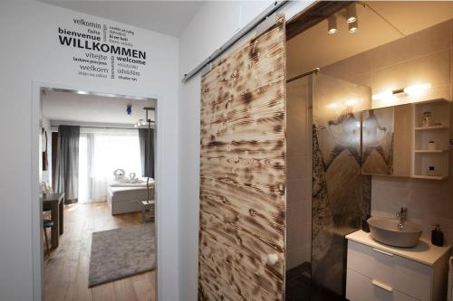 a bathroom with a sliding shower door with a sink at Modern Studio-Apartment in Gosau near Hallstatt in Gosau