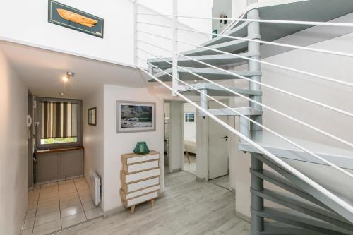 - un escalier en colimaçon dans une maison avec couloir dans l'établissement AIRIAL - Grand Appartement de standing en centre-ville, à Soorts-Hossegor