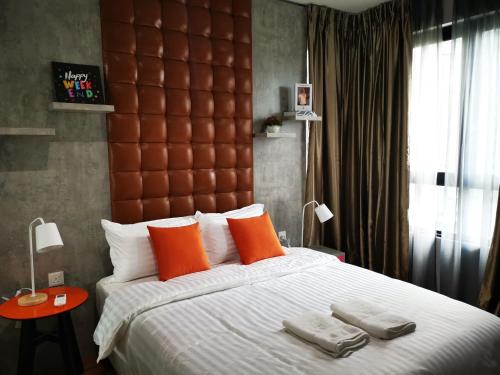 a bedroom with a large bed with orange pillows at Studio Apartment with Balcony by Host Assist i-City in Shah Alam