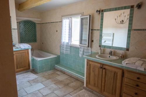 een badkamer met een bad, een wastafel en een bad tubermottermott bij Chateau de Sainte Croix in Carcès