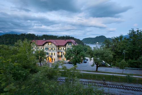 a large house with a river in front of it at Hotel Triglav in Bled