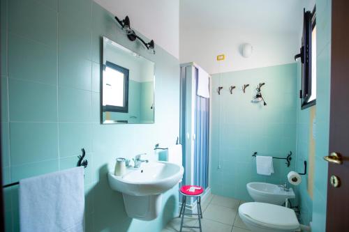 a bathroom with a sink and a toilet and a mirror at Albergo Residenziale Stella Dell'Est in Bari Sardo