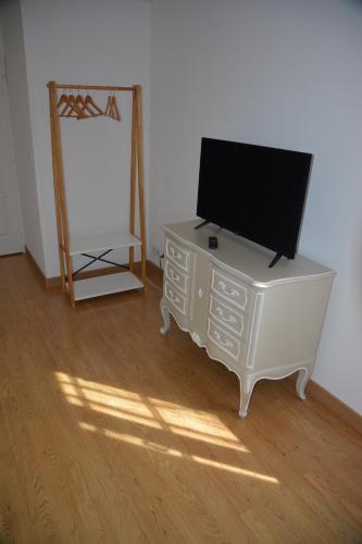 a television on top of a dresser in a room at la maison du saussoy in Saint-Augustin