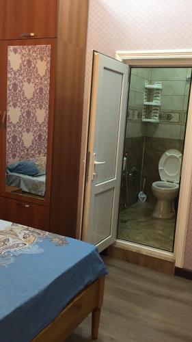 a bathroom with a toilet and a sliding glass door at Hasanovs Villa in Baku