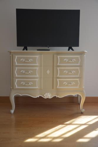 a dresser with a tv on top of it at la maison du saussoy in Saint-Augustin