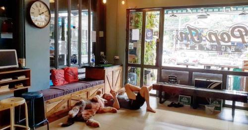 une femme qui se pose sur le sol dans un salon dans l'établissement Pop-In Aonang, à Ao Nang Beach