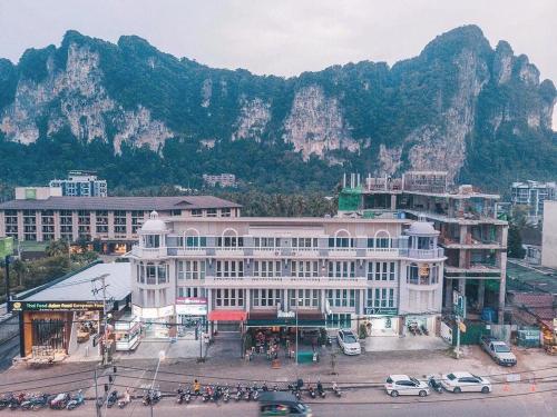 Un grand bâtiment blanc avec des montagnes en arrière-plan dans l'établissement Pop-In Aonang, à Ao Nang Beach