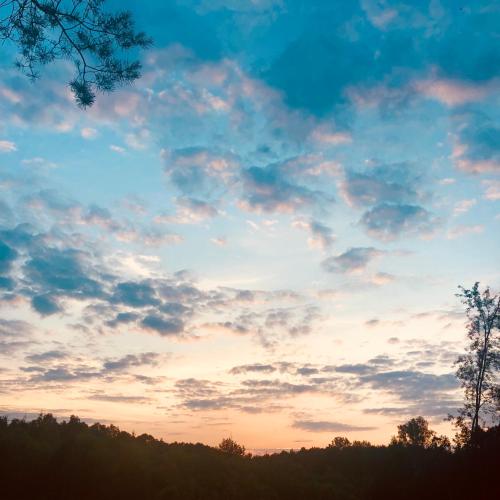 a cloudy sky at sunset with trees in the foreground at WHITE HOUSE - silesian loft apartment in Dąbrowa Górnicza