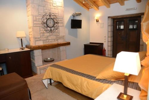 a bedroom with a bed and a stone wall at Archontiko Deligianni in Dhimitsana