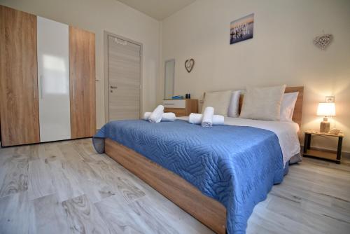 a bedroom with a large bed with a blue blanket at Blue Sea Y in Kavála