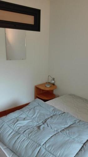 Ce lit se trouve dans une chambre dotée d'une couverture bleue. dans l'établissement Charmant T2 avec cabine fermée et terrasse, aux Angles