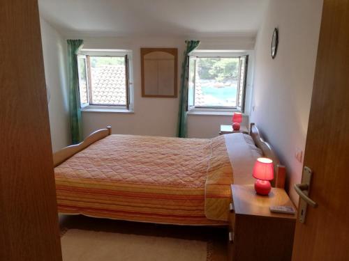 1 dormitorio con 1 cama y 2 ventanas en Apartments Ana Pogana en Punta Križa