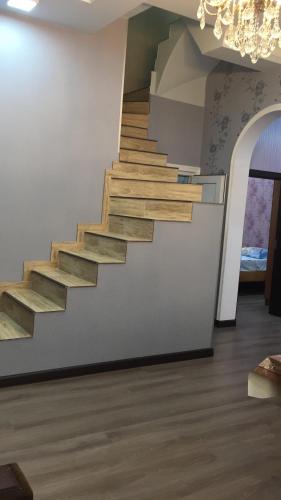 a staircase in a living room with a chandelier at Hasanovs Villa in Baku