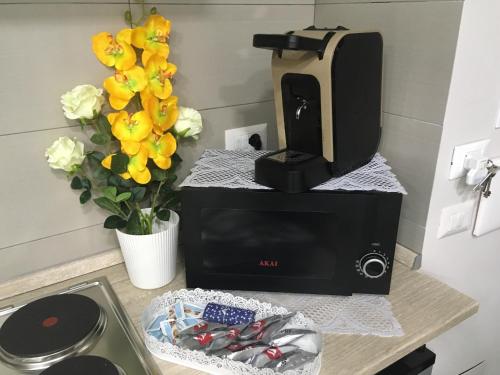a coffee maker sitting on a counter with flowers at casa piano zero in Naples