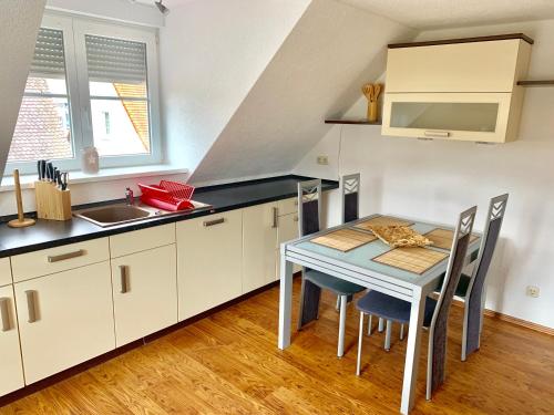 eine Küche mit einem Tisch und einem Waschbecken in der Unterkunft Ferienwohnungen Grimma 3 in Grimma