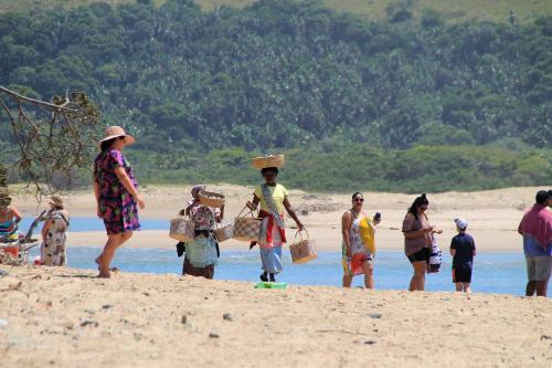 a group of people standing on a beach at Neptunes Cove in Kei-mouth Village
