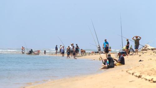 a group of people sitting on the beach at Neptunes Cove in Kei-mouth Village