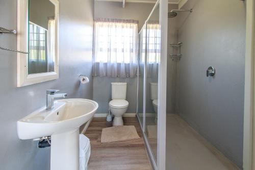 a bathroom with a sink and a toilet at Neptunes Cove in Kei-mouth Village