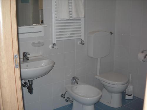 a white bathroom with a toilet and a sink at Agriturismo Campi Di Grano in Roncade