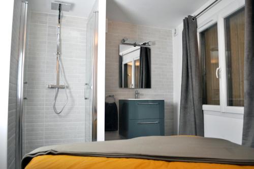 a bathroom with a shower and a bed in it at Ibanova Appartements in Collioure