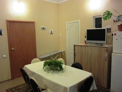 uma sala de jantar com uma mesa, uma televisão e um frigorífico em Ludmila guest house - гостевой дом "Людмила" em Odessa