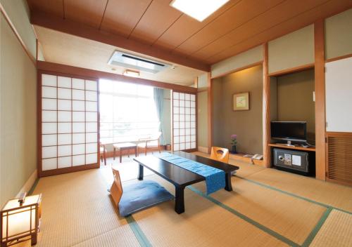 a living room with a table and a tv at Awakan in Sumoto
