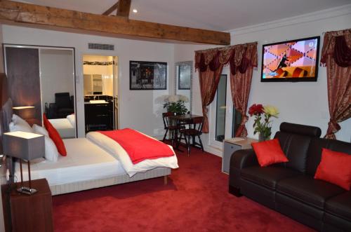a hotel room with a bed and a couch at Hotel Regina Montmartre in Paris