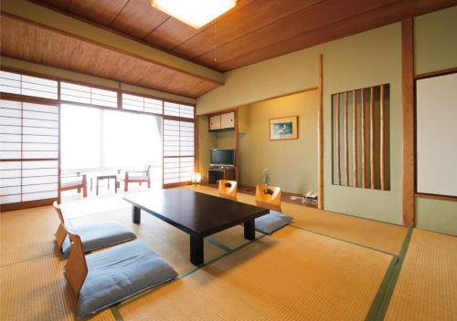 a living room with a table and chairs in a room at Awakan in Sumoto