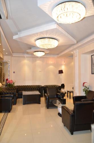 a living room with couches and chairs and chandeliers at Hotel Regina Montmartre in Paris