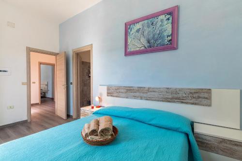 sypialnia z niebieskim łóżkiem z koszem w obiekcie B&B Più Mare w mieście Santa Maria Navarrese