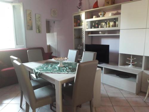 Fresca e comoda في فولونيكا: غرفة طعام مع طاولة وكراسي