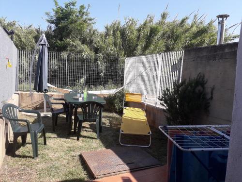 Fresca e comoda في فولونيكا: حديقة خلفية بها طاولة وكراسي وسياج