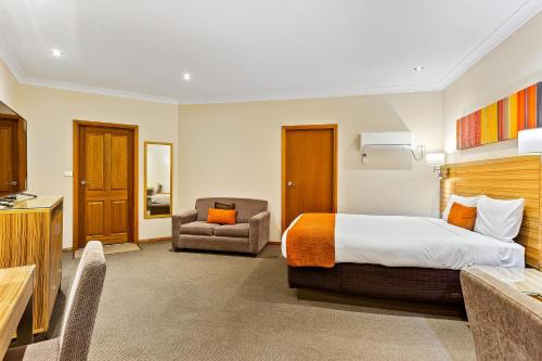 a hotel room with a bed and a chair at Julie-Anna, Bendigo in Bendigo