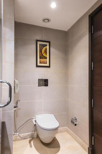 a bathroom with a toilet and a shower at Gurmon Hotels Sohna Road Gurugram, a member of Radisson Individuals in Sohna