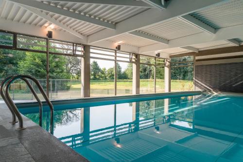 - une piscine intérieure avec vue sur l'eau dans l'établissement Hôtel Château Tilques, à Tilques