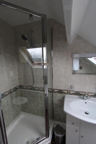 a bathroom with a shower and a sink and a tub at Fern Howe Guest House in Keswick