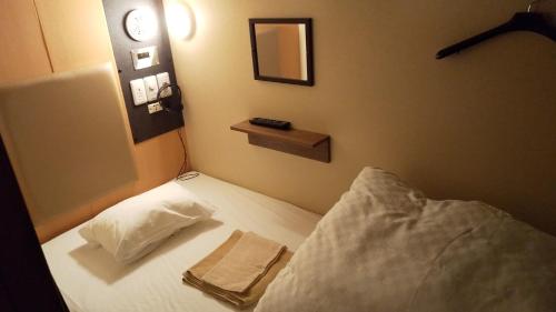 a bedroom with a bed with a towel on it at Guesthouse kukuru in Wakayama
