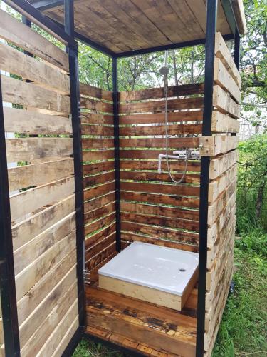 um chuveiro numa parede de madeira com um WC em Retezat Retreat - wood cabin em Clopotiva