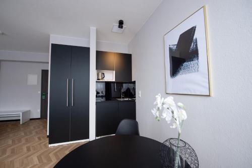 a living room with a table and a kitchen at V Business Appartments Stuttgart Magstadt in Magstadt