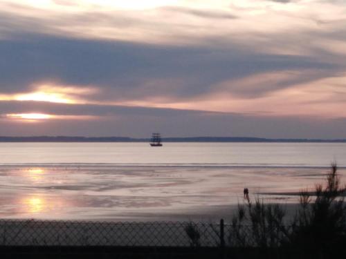 a boat in the middle of the water at sunset at L'APPART DU RIS in Douarnenez