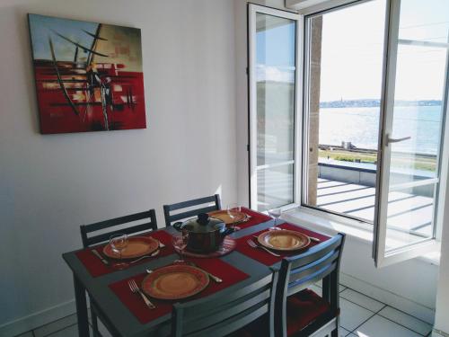 een tafel met twee stoelen en een tafel met bij L'APPART DU RIS in Douarnenez