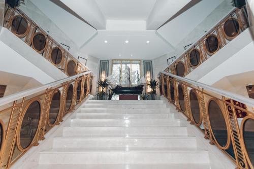 a staircase in a house with wooden railings at Soluxe Hotel Almaty in Almaty