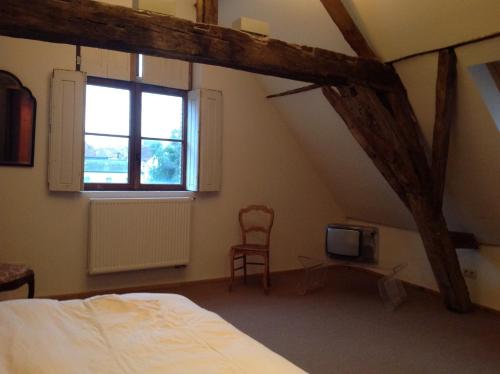 1 dormitorio con cama, ventana y silla en Geldmunt Apartment, en Gante