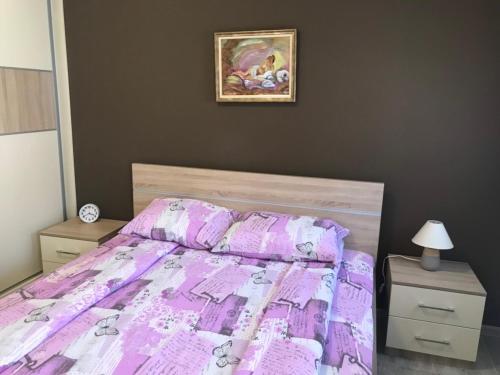 ein Schlafzimmer mit einem Bett mit einer lila Bettdecke in der Unterkunft Apartman Sofia in Vrnjačka Banja
