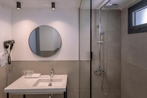 a bathroom with a sink and a shower with a mirror at GHT Sa Riera in Tossa de Mar