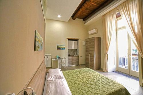 - une chambre avec un lit vert et une grande fenêtre dans l'établissement Casa Amato, à Naples