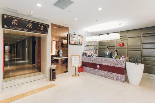 a restaurant with a man sitting at a counter at Soluxe Hotel Almaty in Almaty