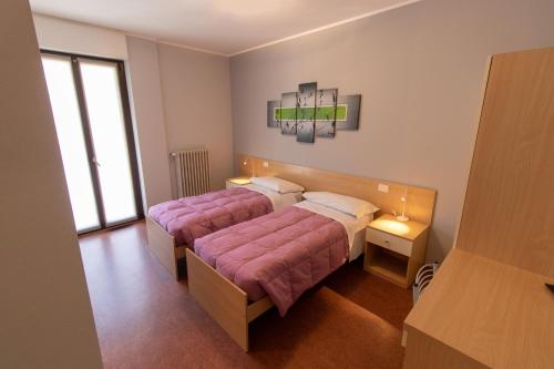 En eller flere senge i et værelse på Hotel del Boschetto