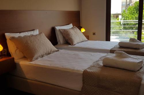 two twin beds in a room with a window at Double View Apartment in Agia Marina Nea Kydonias